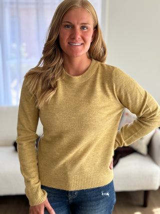Woman wearing a yellow sweater in a living room setting