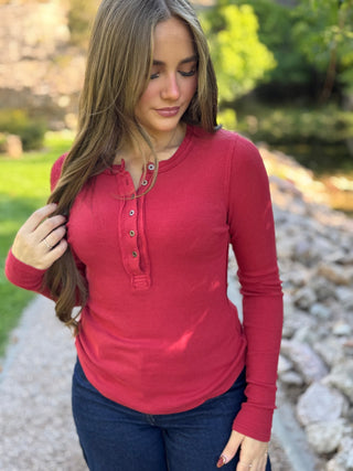 Woman in a red ribbed henley long sleeve top with dark jeans | V-Rae's Boutique