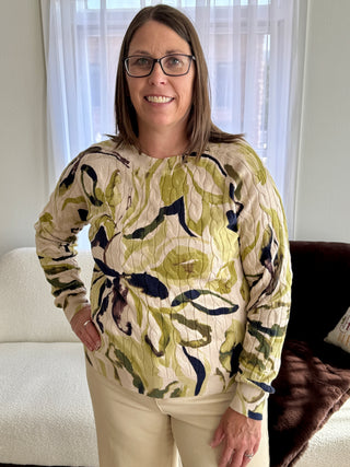 Woman wearing a patterned sweater standing in a living room.