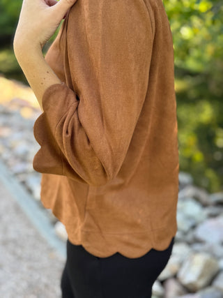 Close-up of the scalloped bell sleeve on a cognac faux suede blouse | V-Rae's Boutique