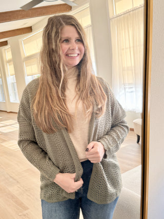 Woman wearing a green cardigan in a home setting