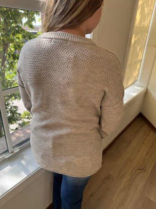 Person wearing a beige mesh face mask indoors with a window in the background
