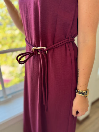 Maroon dress with a belt worn by a person, blurred background