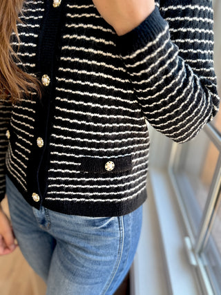 Close up of the details of the black and white button up cardigan.