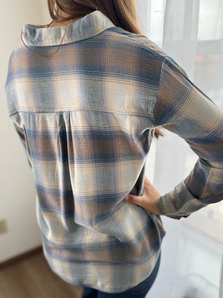 Person wearing a plaid shirt with a neutral background