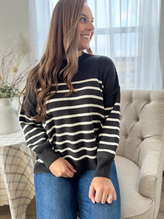 Woman wearing a black and white striped sweater in a living room setting