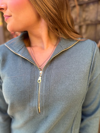 Close-up of the gold zipper on a slate blue half zip sweater | V-Rae's Boutique