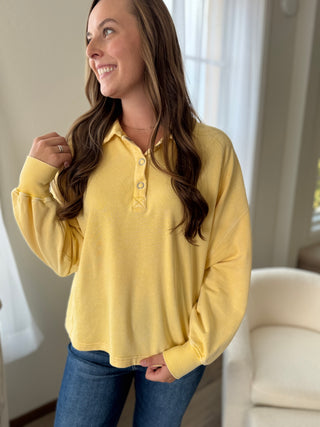 Woman wearing a yellow long-sleeve shirt in a home setting