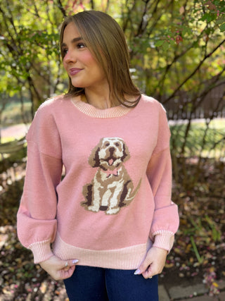 Woman in a pink Brooks puppy knit sweater with dark jeans | V-Rae's Boutique