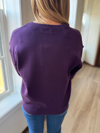 Photo of a woman in a plum sweater.