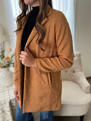 Person wearing a brown textured coat in a home setting