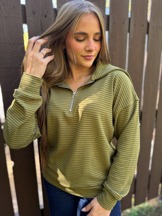 Woman in an olive striped quarter-zip pullover with dark jeans | V-Rae's Boutique