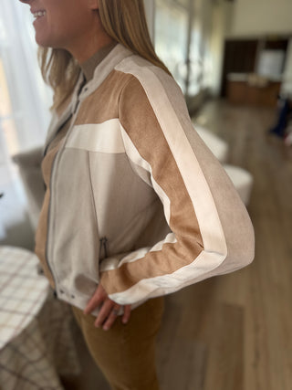 Person wearing a beige and brown jacket indoors