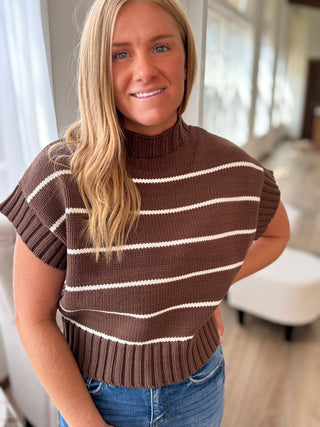 Woman wearing a brown and white striped sweater in an indoor setting