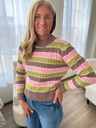 Woman wearing a colorful striped sweater in a home setting