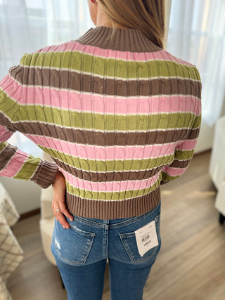 Person wearing a striped sweater with a blurred background