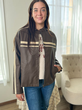 Woman wearing a brown jacket with white stripes indoors