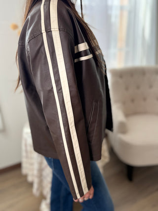 Brown jacket with white stripes worn by a person indoors