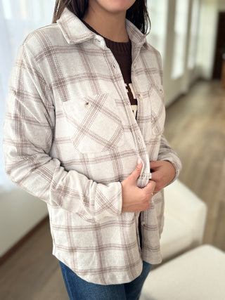 Person wearing a plaid shirt in an indoor setting