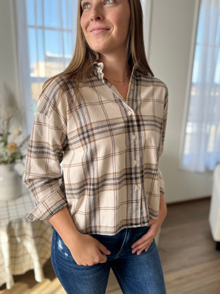 Woman wearing a plaid shirt and jeans indoors