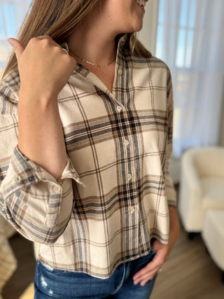 Woman wearing a plaid shirt in a home setting