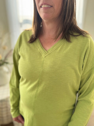 Woman wearing a green long-sleeve shirt indoors