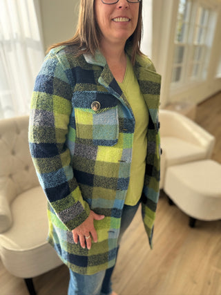 Person wearing a plaid coat in a room with white furniture