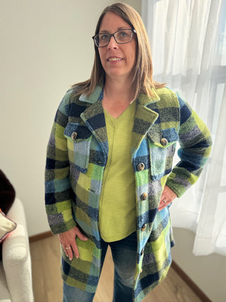 Woman wearing a colorful plaid coat indoors