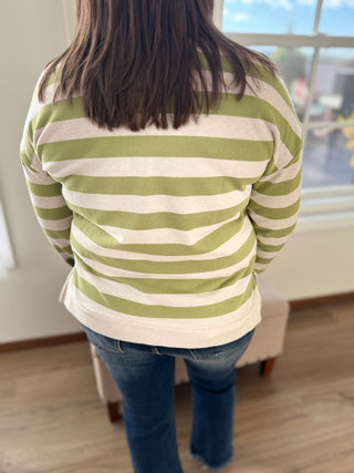 Person wearing a green and white striped shirt in an indoor setting
