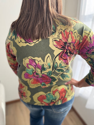 Person wearing a colorful floral-patterned shirt indoors