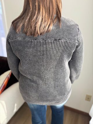 Person wearing a gray sweater with a white background
