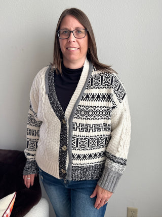 Woman wearing a patterned cardigan against a plain background
