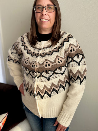 Person wearing a patterned sweater against a plain background