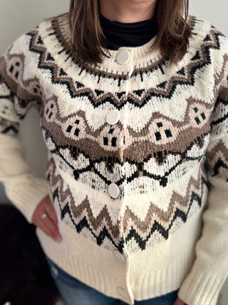 Person wearing a patterned sweater with buttons against a neutral background