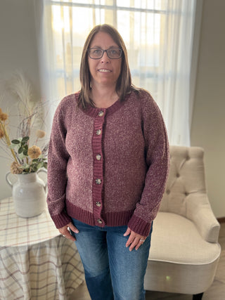 Woman wearing a maroon cardigan in a home setting