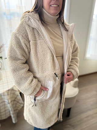 Person wearing a beige fleece jacket indoors