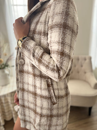 Person wearing a plaid coat in a home setting