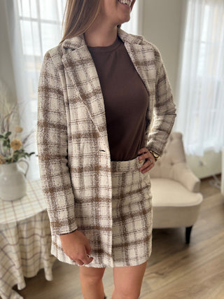 Woman wearing a plaid blazer and skirt set in a home setting