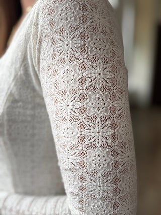 Close-up of a white lace sleeve on a blurred background