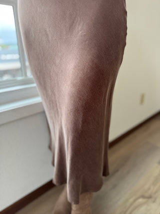 Brown skirt on a person standing by a window with a blurred background