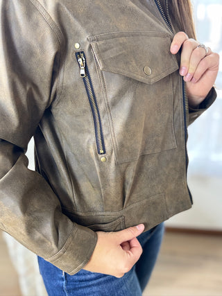 Brown leather jacket with a zipper detail on a blurred background