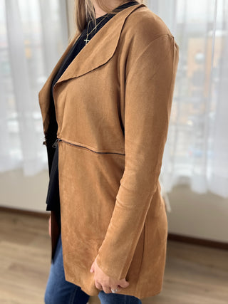 Person wearing a brown coat with a blurred background