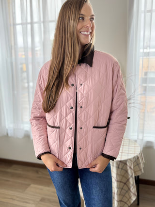 Woman wearing a pink quilted jacket indoors