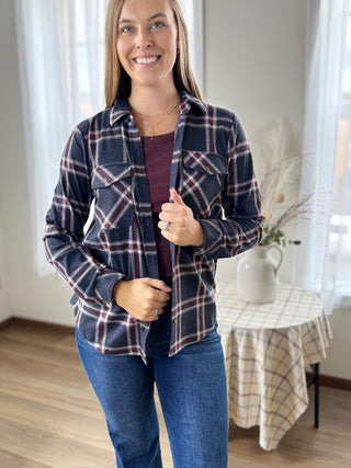 Woman wearing a plaid shirt and jeans indoors