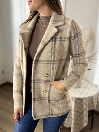 Woman wearing a plaid coat with a neutral background