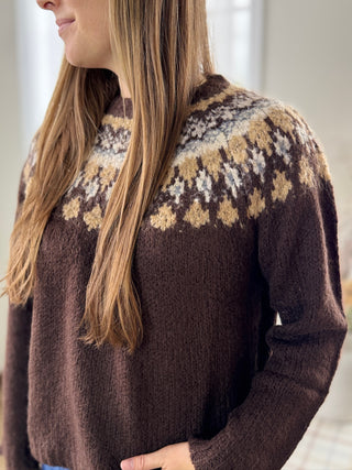 Person wearing a brown sweater with a patterned design