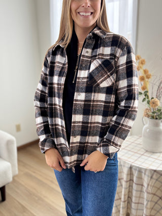 Woman wearing a plaid shirt in a home setting