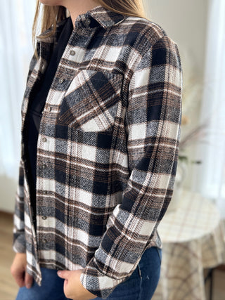 Person wearing a plaid shirt with a blurred background