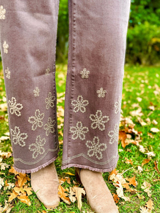 Close-up of the floral embroidered hem on mauve jeans | V-Rae's Boutique