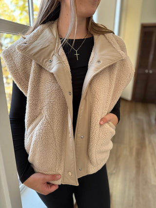 Person wearing a beige fleece vest indoors